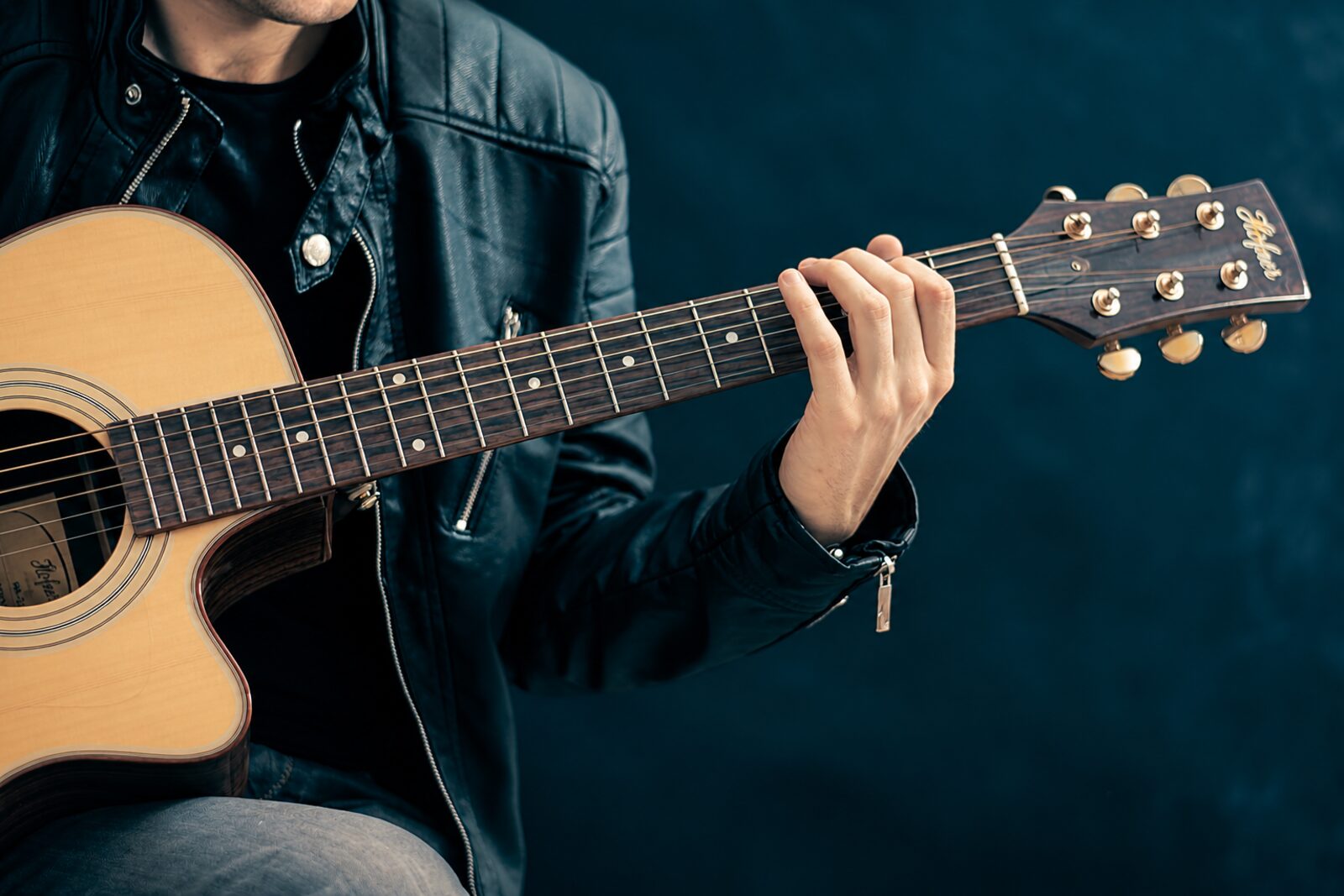 Close-up of a student's hand shaping a chord on the guitar