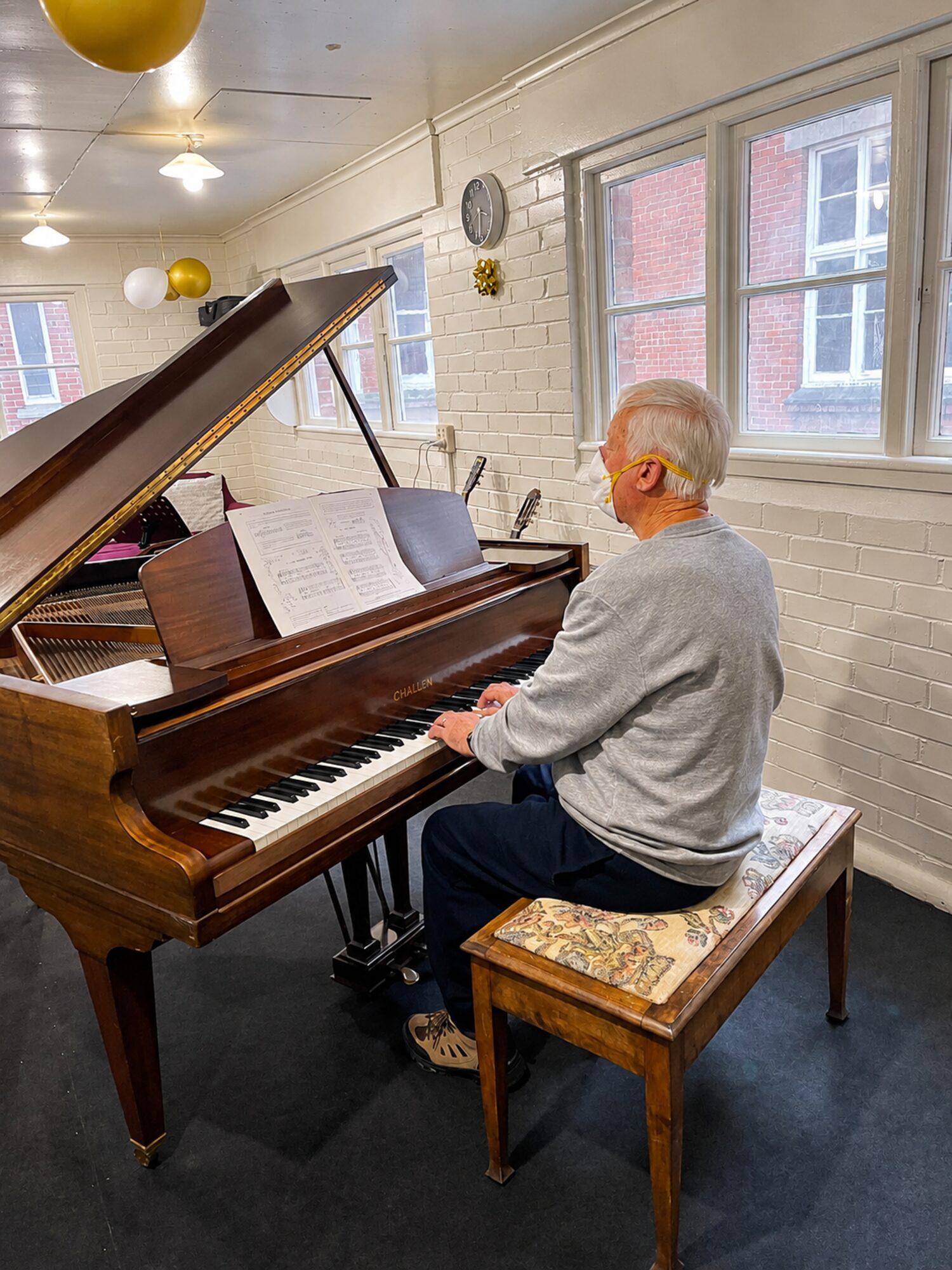 An adult student practising at the grand piano