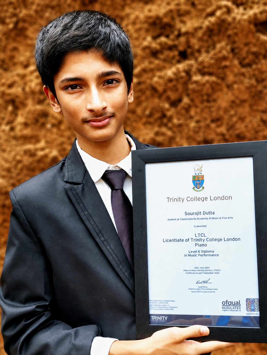 A student holding a Trinity College London music diploma